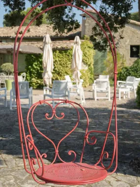 Pair of hanging red metal swings from the oak tree