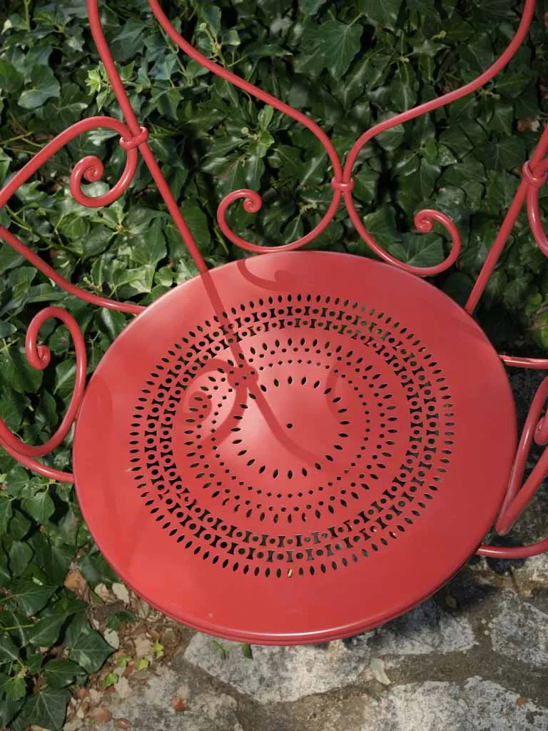 Pair of hanging red metal swings from the oak tree